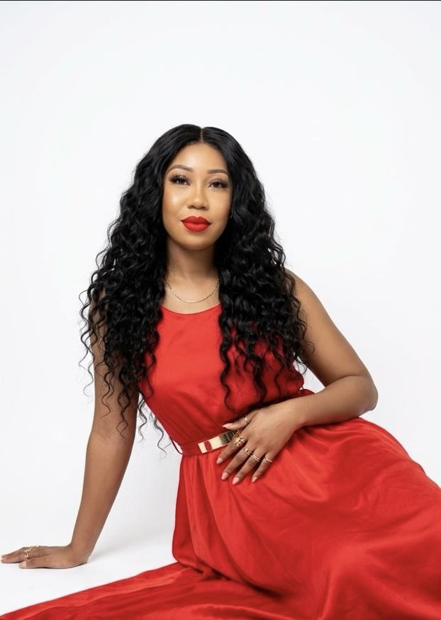 Ekpenyong Boluwatife seated in a flowing red dress